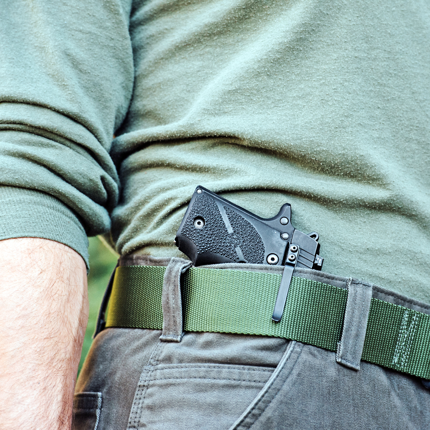 An individual using a Clipdraw gun clip to wear his pistol in the appendix carry position.