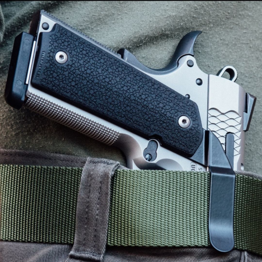 A handgun worn inside-the-waistband using a Clipdraw gun belt clip.